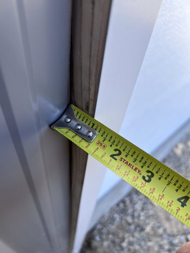 A tape measure being used to measure a garage door frame, indicating precise installation work by Overhead Door Company of Santa Fe in Santa Fe, NM.