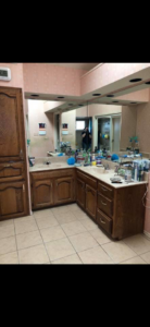 A messy bathroom vanity with two sinks and many toiletries before professional cleaning by Klean Living in Lawson, Dallas, TX.