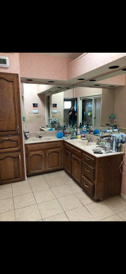A messy bathroom vanity with two sinks and many toiletries before professional cleaning by Klean Living in Lawson, Dallas, TX.