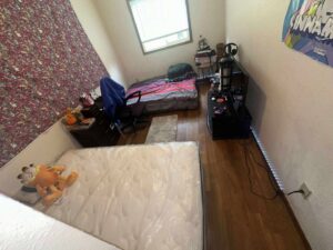 A messy bedroom before professional house cleaning and organization services by Nannie Needs LLC in Kent, WA.