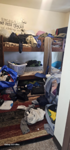 A messy room with bunk beds and clothes on the floor, showing a before-cleaning scene by Cleaning with Lisseth in Madison, WI.