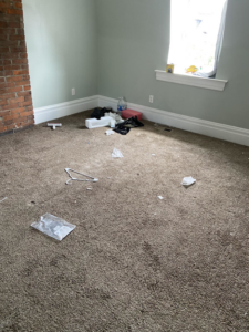 A messy carpeted room with debris on the floor, ready for professional cleaning by Starr's Sparkling Cleaning in St. Louis, MO