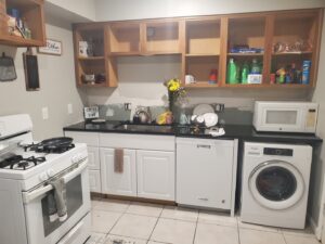 A messy kitchen with dishes in the sink, showing a 'before' scenario for house cleaning by Perfection Cleaning in Kansas City, MO.
