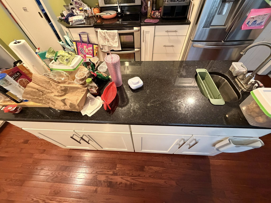 A cluttered and messy kitchen countertop before professional cleaning by Jocelyn's Cleaning Services in Charlotte, NC.