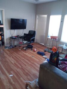 A messy room with items on the floor, awaiting cleaning by Nicoles Cleaning Service LLC in Mobile, AL.