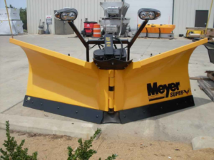 A yellow Meyer Super snow plow, ready for snow removal services by Tulsa snow removal by Kodiak Custom Masonry in Coweta, OK.