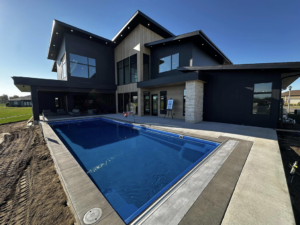 A newly installed modern backyard swimming pool by Pinnacle Homes and Design in Mandan, ND.