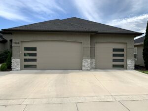 House featuring two modern beige garage doors with horizontal windows installed by Garage Door Store Boise, ID.