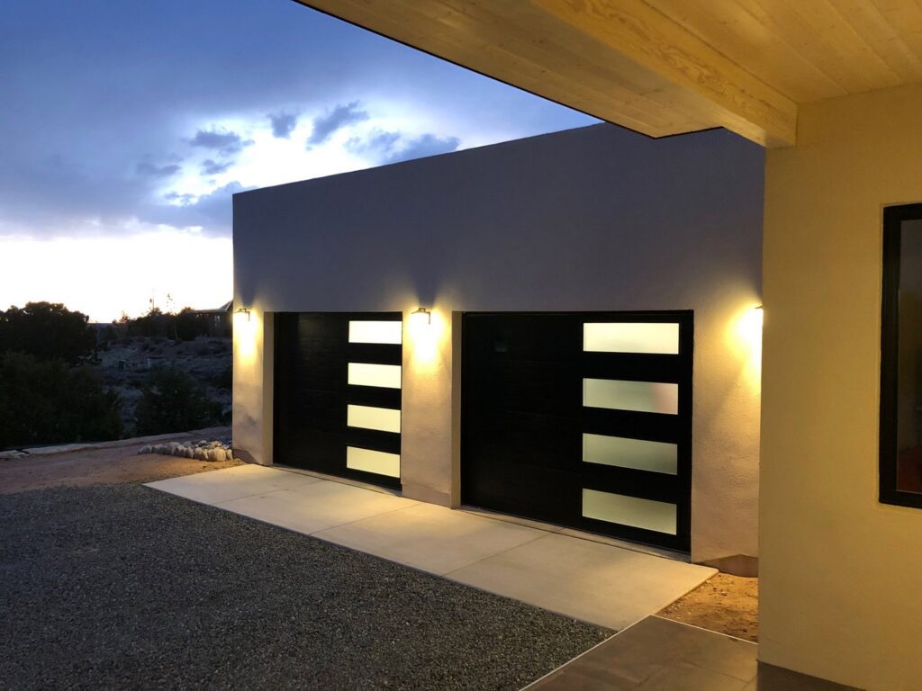 Two modern black garage doors with frosted glass panels installed by Precision Garage Door of Albuquerque and Santa Fe, NM.
