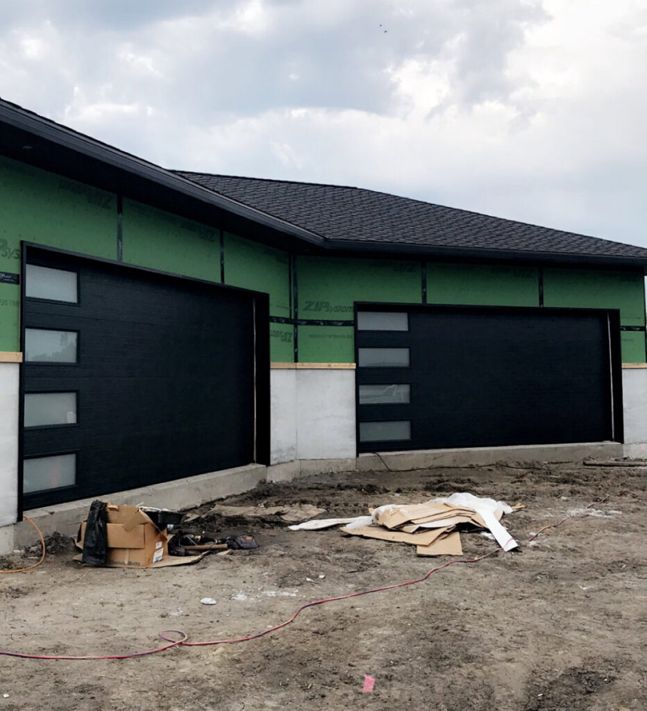 Modern black garage doors with horizontal frosted windows installed on a new construction home by Elite Door in Winchester, CA.