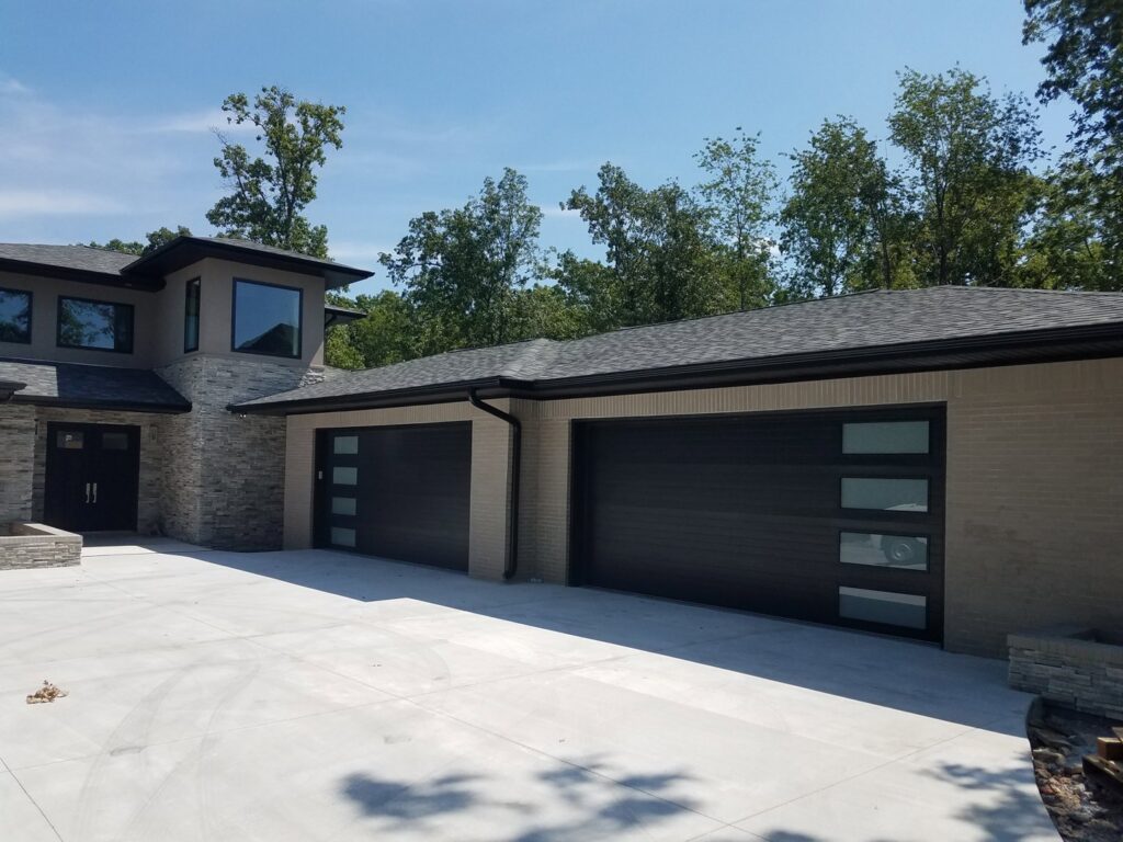 Modern black garage doors installed on a new home by Garage Doors & More in Bentonville, AR