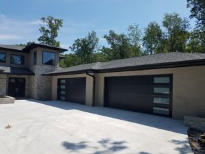 Modern black garage doors installed on a new home by Garage Doors & More in Bentonville, AR