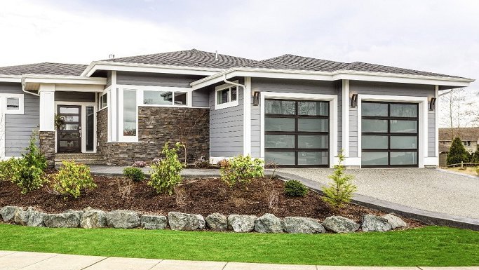 A contemporary house with two sleek black glass garage doors installed by Overhead Door Company of Little Rock in North Little Rock, AR.