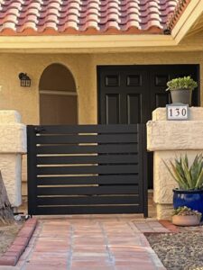 A modern black horizontal slat iron gate installed by Giddy Up Garage Doors & Iron in Las Vegas, NV.