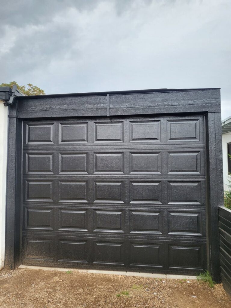 A modern black panel garage door recently installed by Spartan Garage Doors and More in Albuquerque, NM.