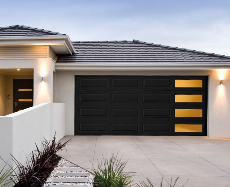 A modern black residential garage door with windows installed by Valley Overhead Door in Las Vegas, NV.
