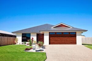 A modern home featuring a sleek brown wood garage door with horizontal windows by The Door Man - Garage Doors & Openers in Reno, NV