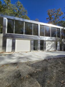 A modern building featuring two newly installed white garage doors by Spring King Garage Doors in Middletown, CT