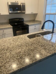 A modern and impeccably clean kitchen with granite countertops, reflecting the quality service of Active Cleaning in Virginia Beach, VA