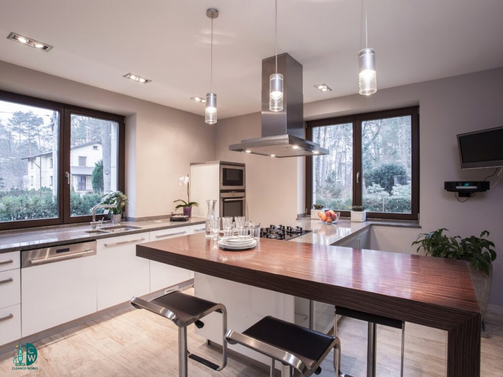 A modern and impeccably clean kitchen featuring an island with bar stools, demonstrating the professional cleaning services of CleanCo Works in Scottsdale, AZ.