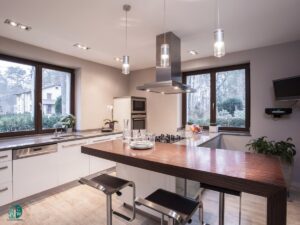 A modern and impeccably clean kitchen featuring an island with bar stools, demonstrating the professional cleaning services of CleanCo Works in Scottsdale, AZ.