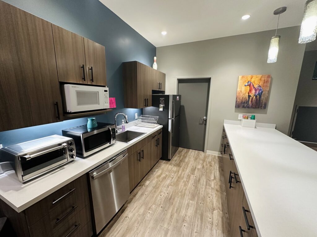 A modern and impeccably clean kitchen with dark wood cabinets and white countertops by Top-Notch Tidy Services in Chesapeake, VA.