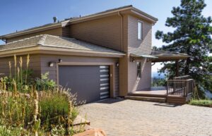 A modern dark grey garage door with horizontal windows, installed by Overhead Door Co of Missoula in Missoula, MT.