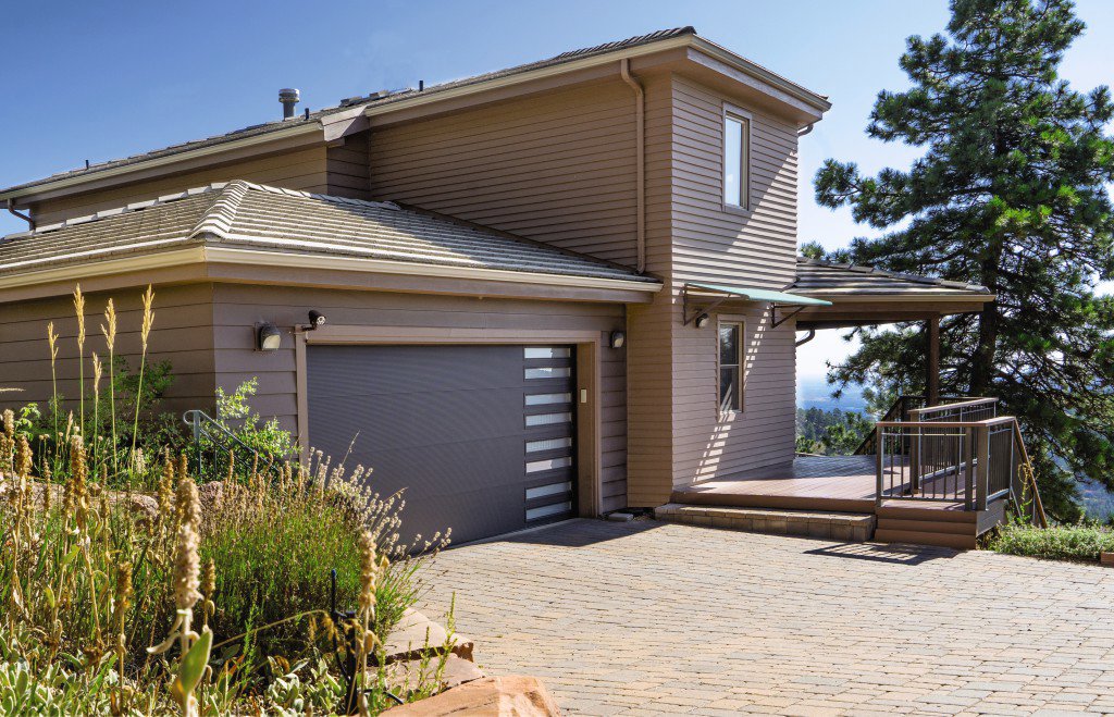 A modern dark grey garage door with horizontal windows, installed by Overhead Door Co of Missoula in Missoula, MT.