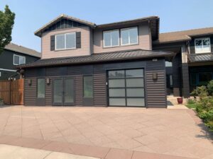 A modern home featuring a dark grey garage door with frosted glass panels installed by The Door Man - Garage Doors & Openers in Reno, NV
