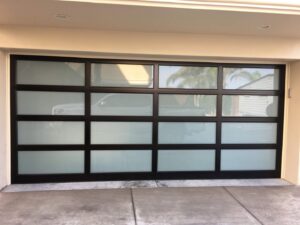 A newly installed modern garage door with frosted glass panels by Rebel Overhead Doors in Las Vegas, NV.