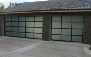 Two modern garage doors with frosted glass panels and dark frames installed on a home by Wahlen Garage Doors in Ogden, UT