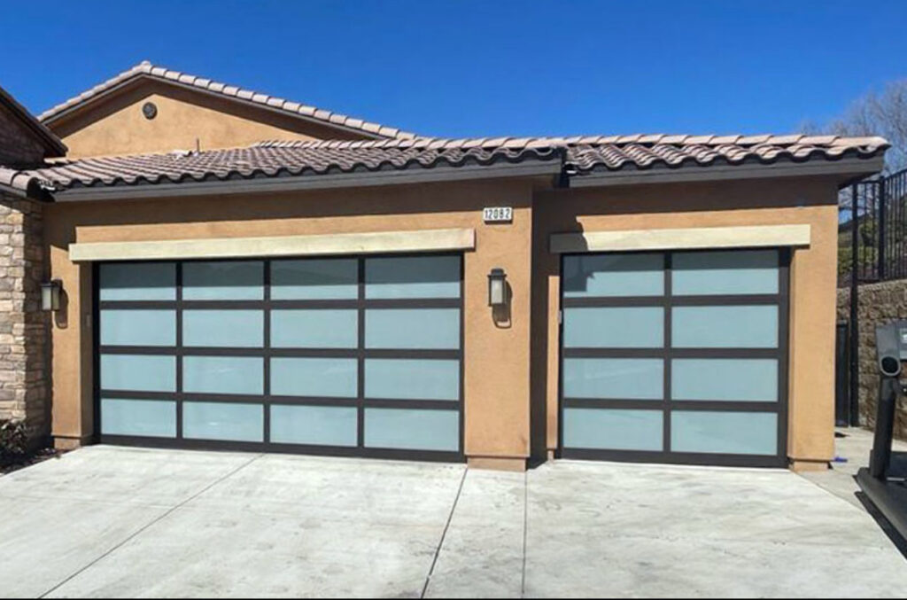 Two modern garage doors with frosted glass panels installed on a house by Apex Garage Doors LLC in Las Vegas, NV