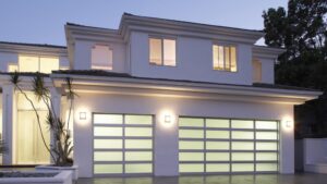 A contemporary home at dusk with two frosted glass garage doors installed by Overhead Door Company of Little Rock in North Little Rock, AR.