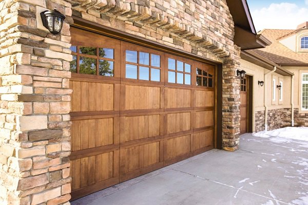Two modern garage doors with blue glass panels on a contemporary home by Custom Overhead Doors of Southern New Mexico in Alamogordo, NM.