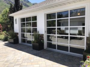 Modern glass garage door installation on a residential home by Up N Over Garage Doors LLC in Layton, UT.
