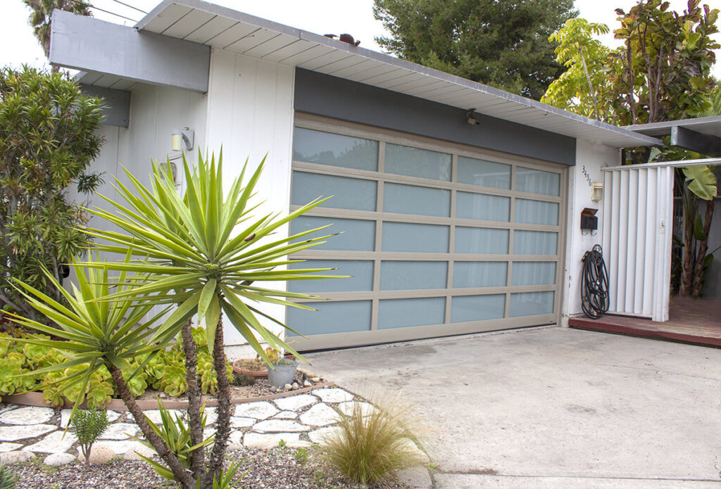 A newly installed modern glass panel garage door on a residential home by Garage Door Medics in Boise, ID.