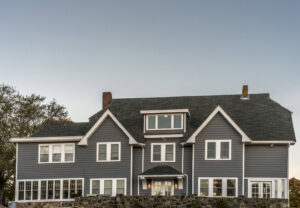 A large modern home featuring new grey siding installed by United Home Experts in Ashland, MA.