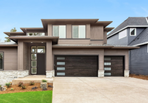 A modern home featuring two dark brown garage doors with frosted glass panels installed by Standard Door Supply in Portland, ME.