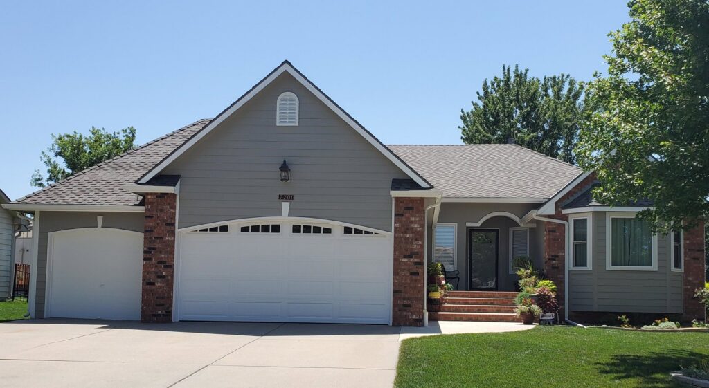 A modern home featuring new gray siding and brick accents installed by River City Exteriors in San Antonio, TX