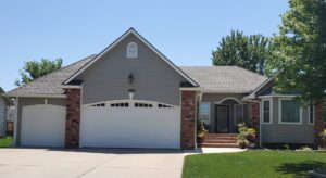 A modern home featuring new gray siding and brick accents installed by River City Exteriors in San Antonio, TX