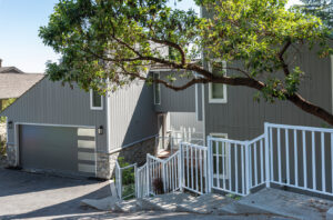 A modern home featuring gray siding and stone accents installed by Ideal Siding Dallas, TX.
