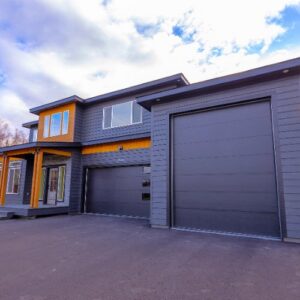 Modern home featuring two dark grey garage doors installed by Elite Doors in Wasilla, AK.