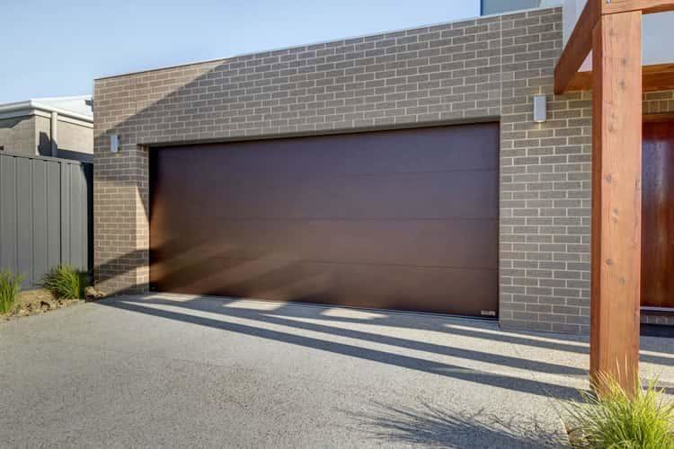 A modern house featuring a brown garage door installed by Up & Down Garage Doors in Bridgeport, CT.