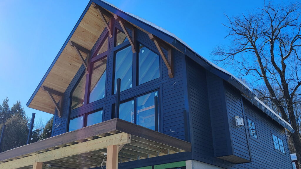 A modern house featuring dark blue siding installed by KC Entities Roofing and Siding in Mechanicville, NY