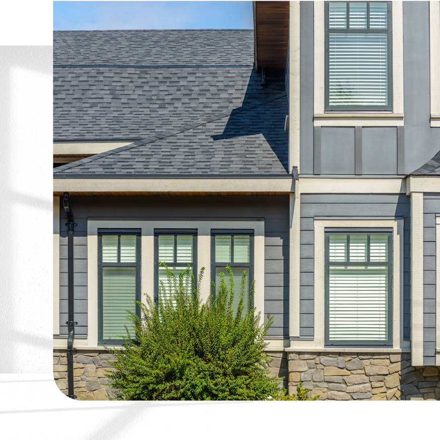 Modern house exterior featuring dark gray siding and stone veneer by Southwestern Remodeling in Wichita, KS