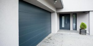 A modern house featuring a dark grey garage door and matching front door installed by Pioneer Overhead Door, Inc in Las Vegas, NV.