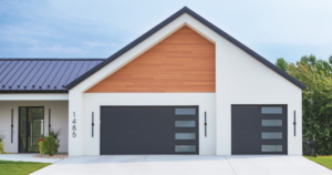 A modern house featuring two dark grey garage doors with windows installed by Bailey Garage Doors MT in Belgrade, MT.