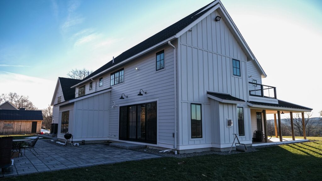 A modern house featuring white vertical board and batten siding, installed by Jonesboro Siding, Window & Door in Jonesboro, AR.
