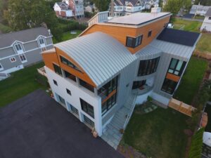 A modern house showcasing a combination of wood panel and sleek metal siding installed by JM Roofing & Siding in Rogers, AR.