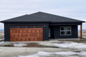 A modern house featuring a stylish wooden garage door installed by PS Garage Doors of Williston, ND.